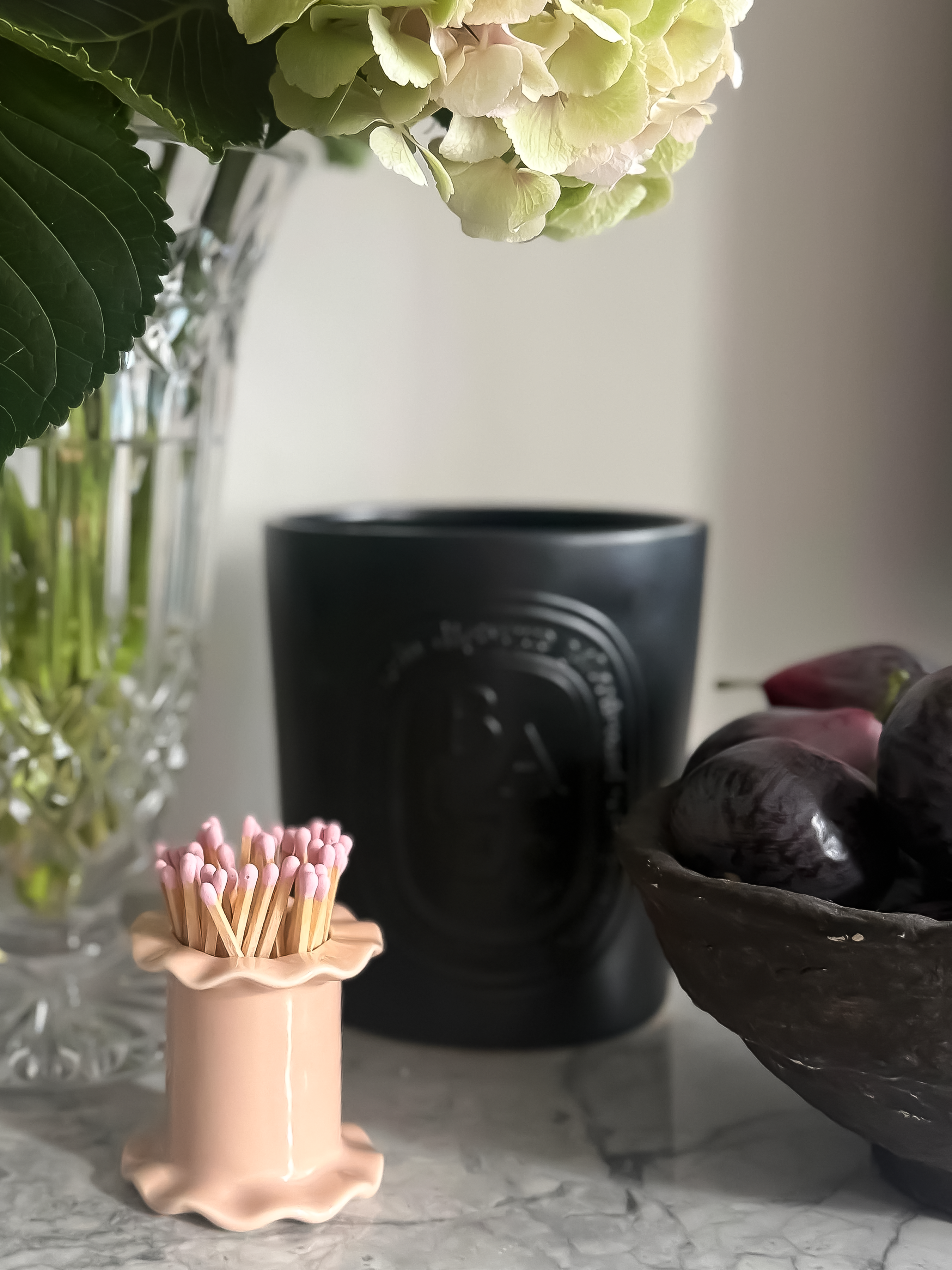 White or pink ceramic ruffle matchstick holder with strike pad on base.