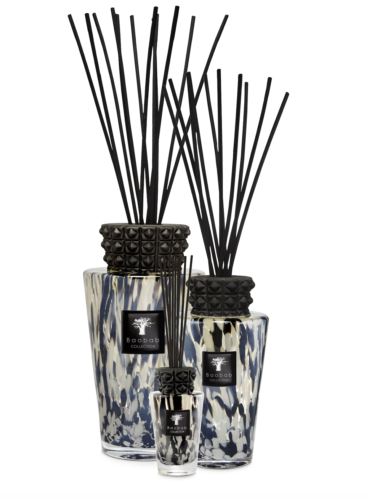 Reed diffuser set with black studded diffuser sticks and decorative bottles on a white background
