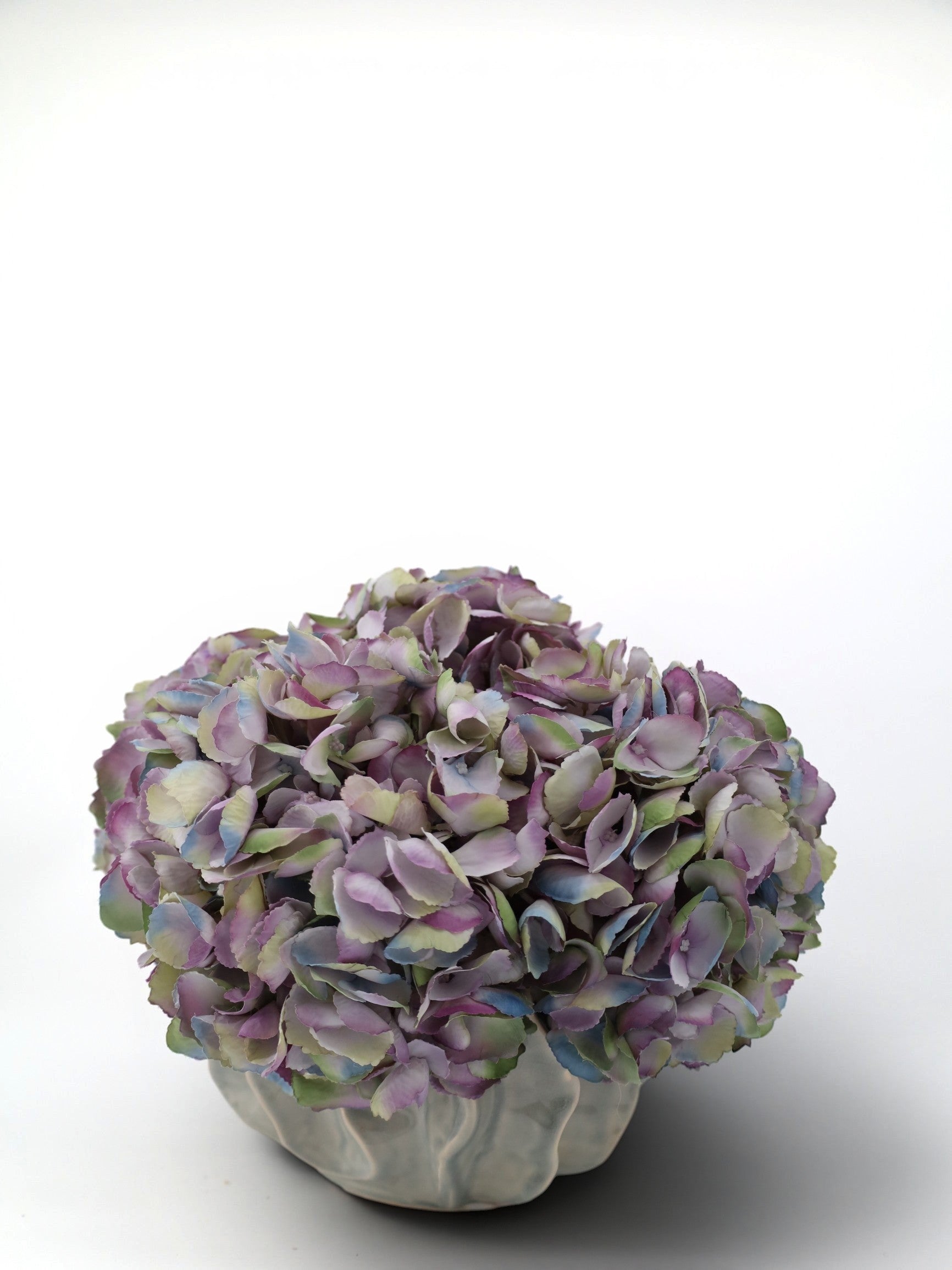 Sixty3 Styled artificial hydrangea arrangement in a ribbed gray ceramic vase with purple, blue, and green blooms.