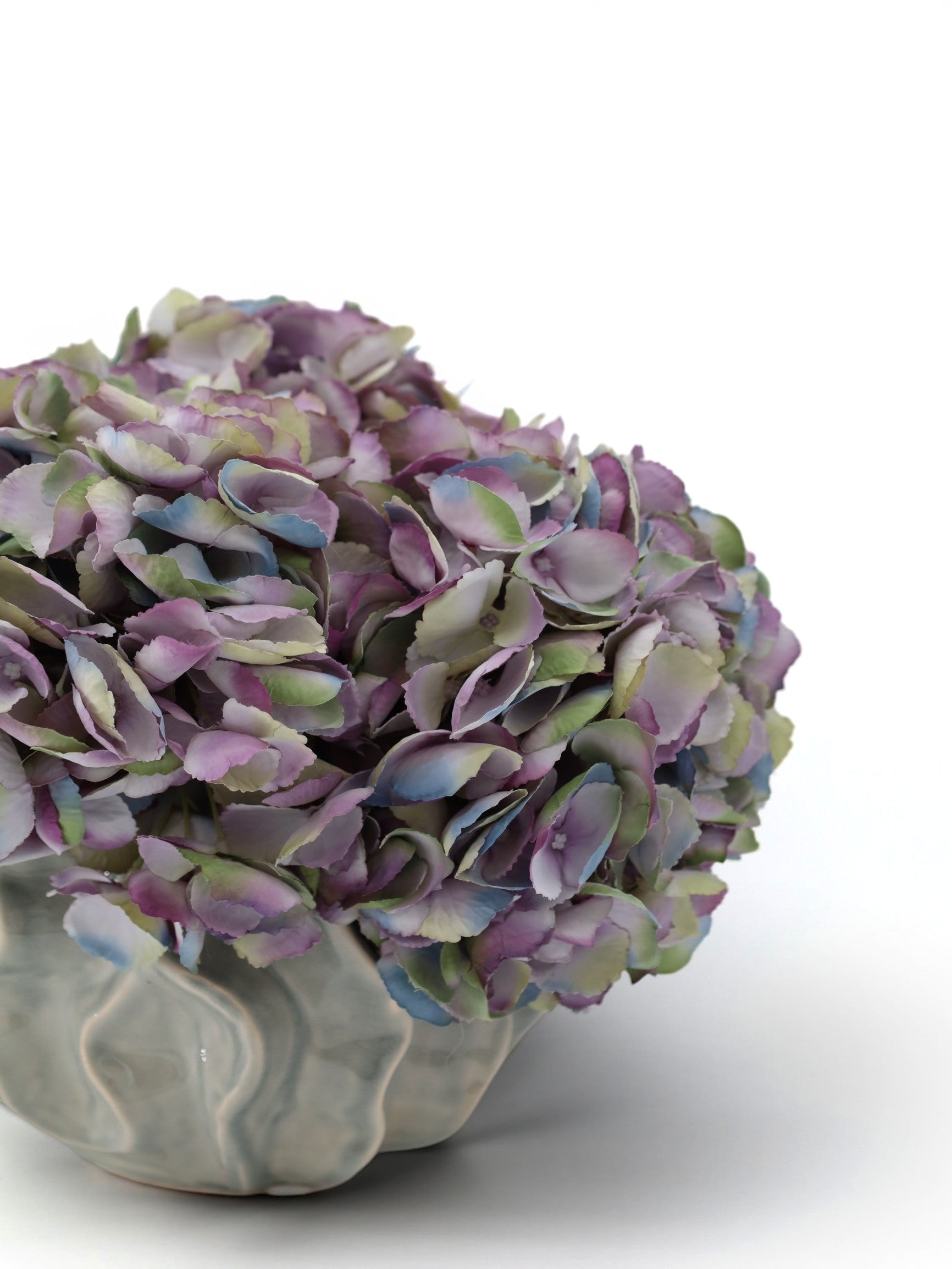 Sixty3 Styled artificial hydrangea arrangement in a light gray ribbed ceramic vase with purple, blue, and green blooms.