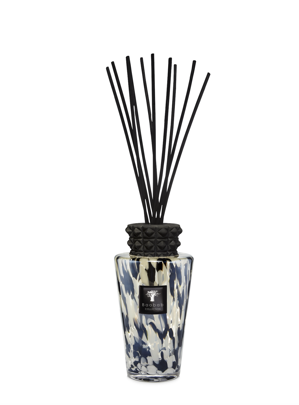Reed diffuser with black sticks in a patterned bottle on a white background