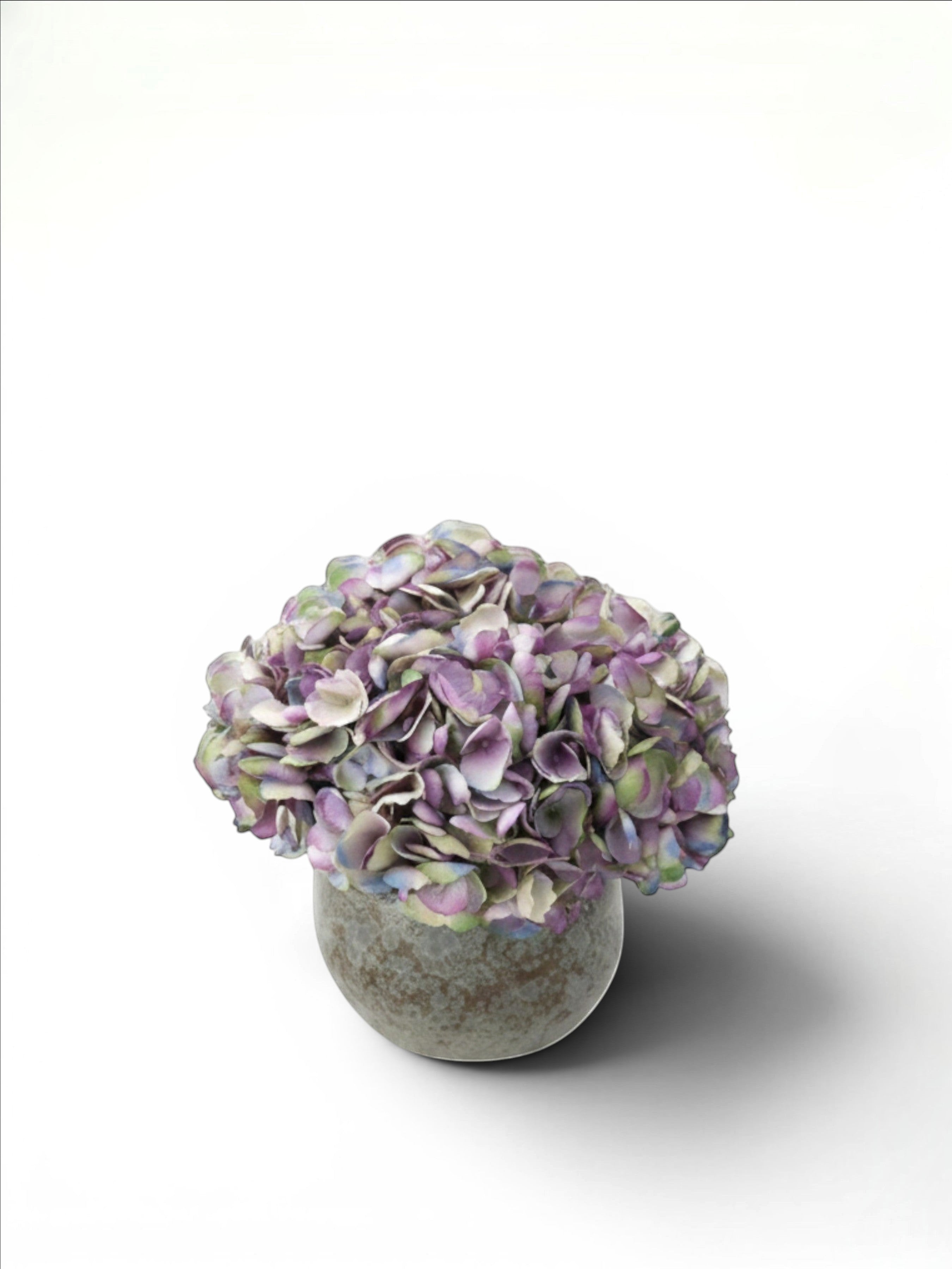 Sixty3 Styled faux hydrangea arrangement in dusty lavender, sage, and ink, in a textured stone vessel.